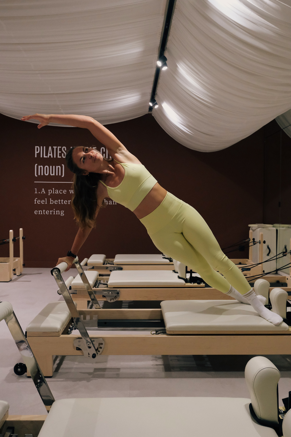 Exercice de planche latérale sur machine Pilates Reformer au studio de Saint-Étienne